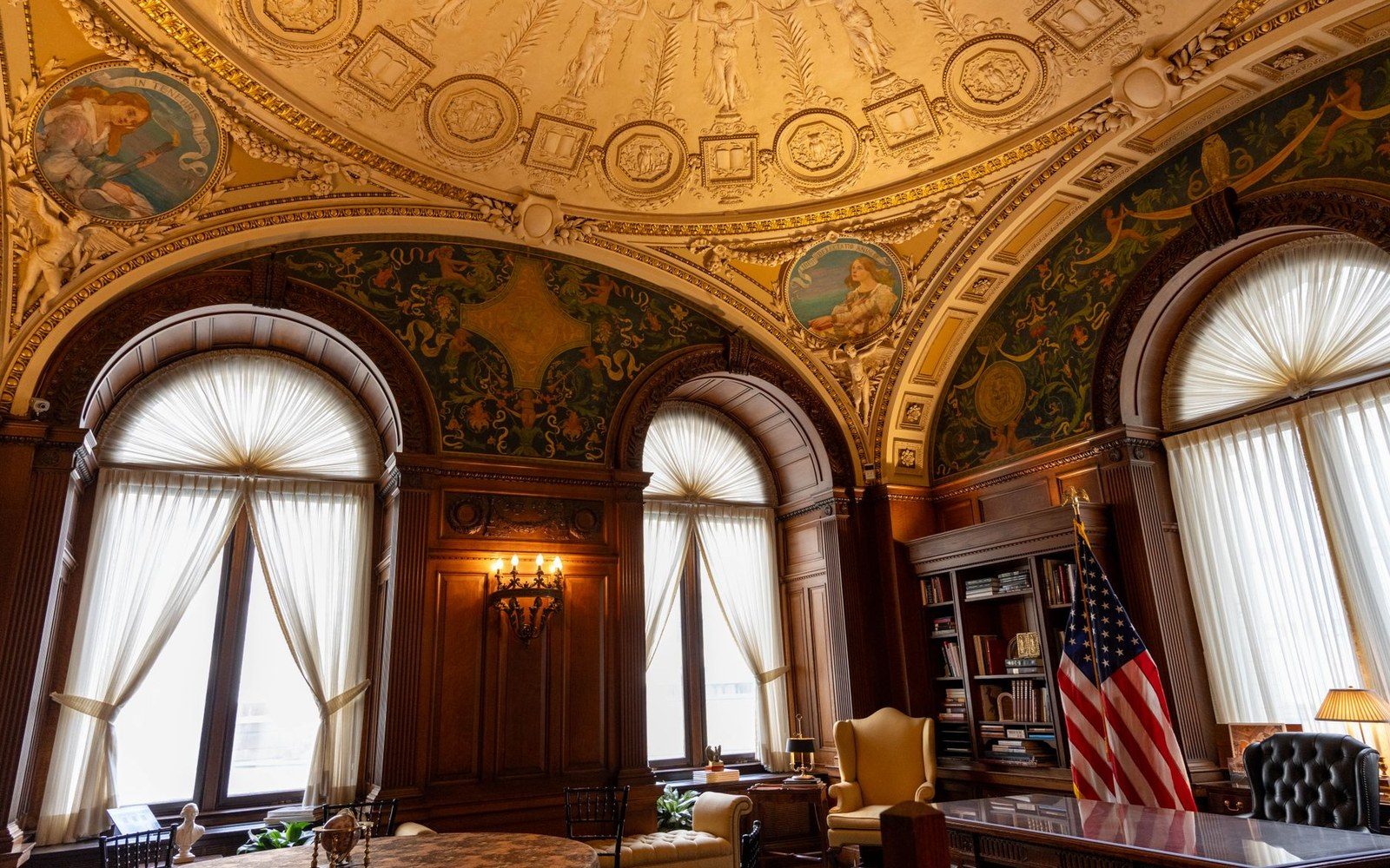 The interior of an FCC hearing room in Washington DC, tiered commissioner seats facing a public gallery, fluorescent light on wood panelling
