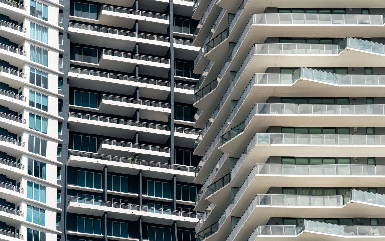 Rows of stacked balconies on adjacent high-rise residential towers viewed up close