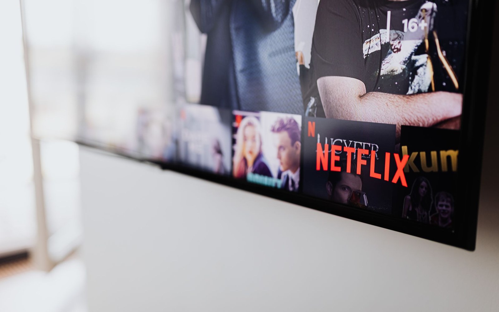 Wall-mounted television displaying the Netflix streaming app home screen at an angle